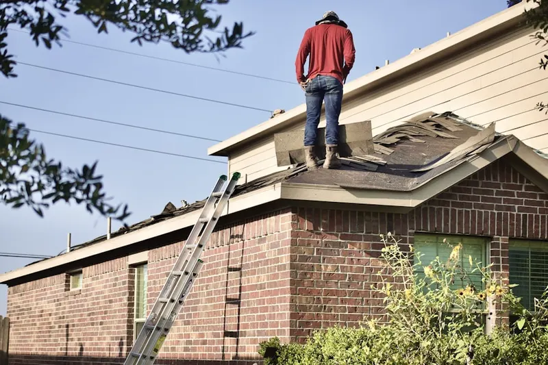 Professional roofer working on a residential roof in Bingham Farms